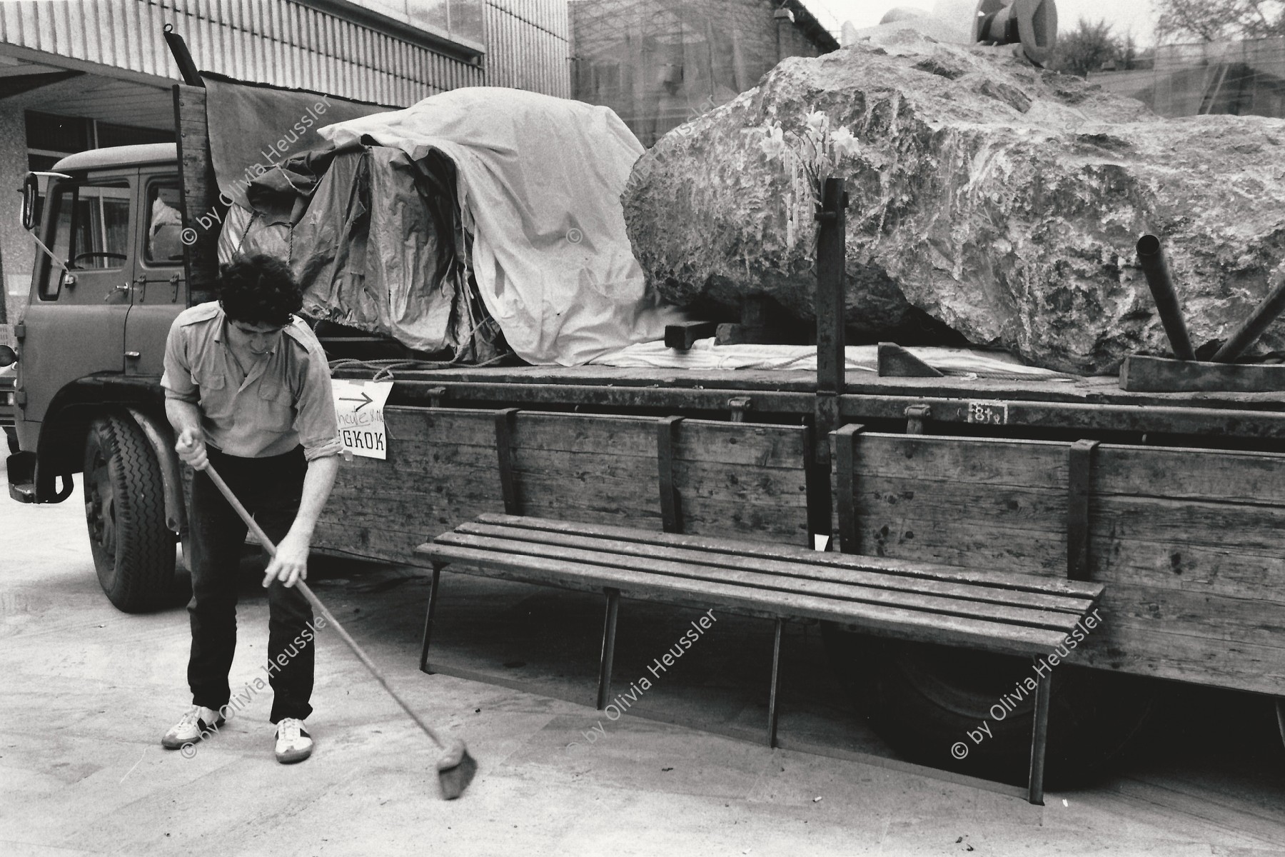 Image of sheet 19820190 photo 4: Mike Hentz mit dem Projekt Minus Delta t vor der Abfahrt nach Bangkok mit einem tonnenschweren Findling auf dem Lastwagen 

Die Gruppe Minus Delta T ist bekannt für Ihre Performances/Aktonen. Die Aktion Stone - der Stein kommt aus dem Steinbruch wo auch die Steine von Stonehenge gebrochen wurden. Man konnte Kiloweise sich an dem Stein beteiligen, der Stein ist auf dem Landweg in den Himalaya gefahren worden, wor er noch heute ist. Steinaustausch -
Kulturaustausch.


Kunsthaus Zürich. 1982 √