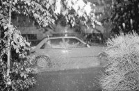 Image of sheet 19820220 photo 19: Ein Fahrzeug fährt an der Weinbergstrasse durch strömenden Regen, Zürich 1982.