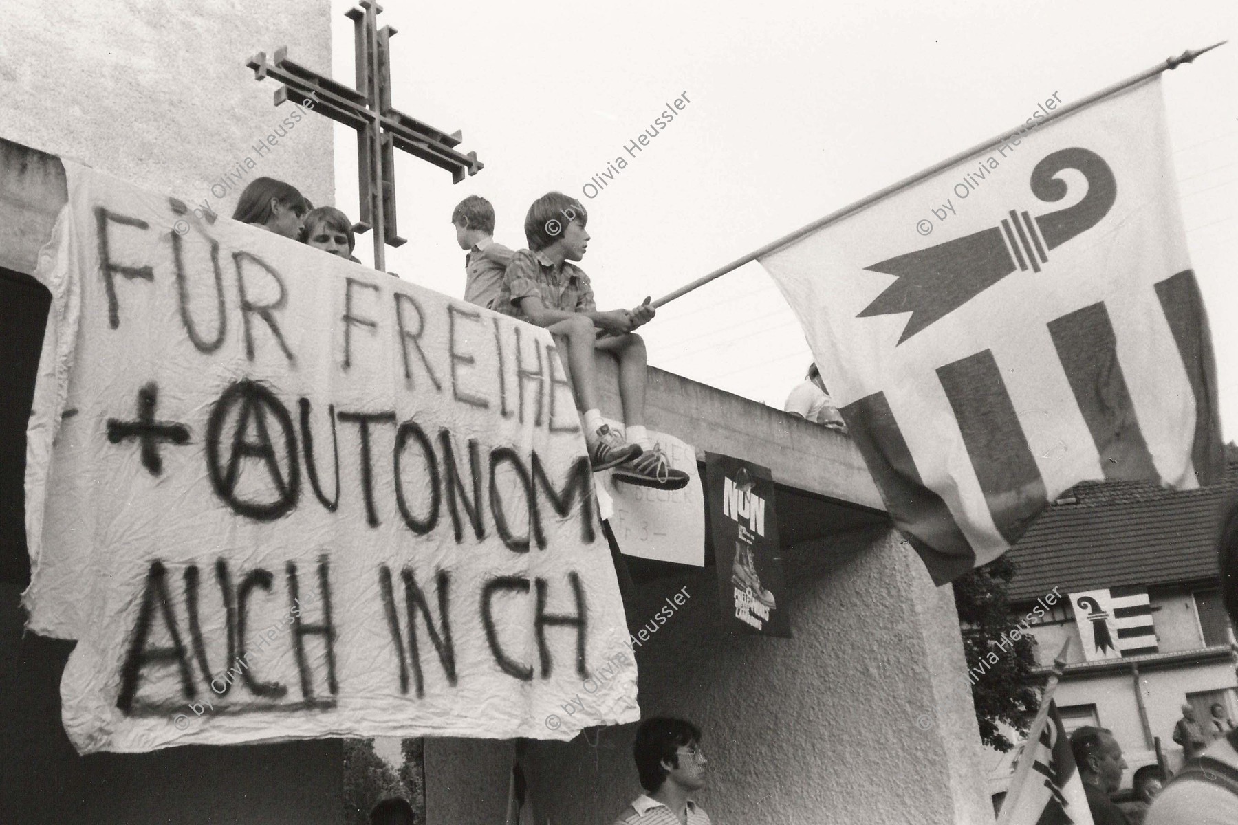 Image of sheet 19820300 photo 20: Roland Béguelin (* 12. November 1921 in Tramelan; † 13. September 1993 in Delémont) war ein Schweizer Politiker und Hauptvertreter der jurassischen Separatisten in der Jurafrage.
Kind mit Jurafahne Für einen Kanton Jura.
Transpi: Für Freiheit und Autonomie auch in der Schweiz. Kirche und Fahne. Schweiz Vellerat 1982 √ 
Swiss Switzerland Schweiz Svizzera Suisse Europe protest national nationalism new canton founding generation autonomy