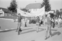 Image of sheet 19820301 photo 18: Aussersihler Bewegung macht Solidaritätsmarsch mit. Romano und Christoph  Schuler mit Kahlschnitt (ohne Haare) tragen Transparent. Oui=Libert. Beguelin führt Marsch an. Poste Frontiere Comune Libre Vellerat gibt eigens gedruckte Identitätskarten 
Jura libre Fahne. Frau filmt den Marsch. 
Kanton Jura 1982