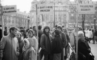 Image of sheet 19820360 photo 10: Zwei Pudel treffen sich inmitten einer bevölkerten Fussgängerpassage in Paris. Charles Jourdan Mode Laden. Schuhe Schaufenster. Chatelet Video überwachung. Kind mit Pistole Briefmarkensammler und verkäufer. Kino anstehen. Metro. Station. Obdachloser liegt auf Karton. Menu wird angepriesen. Alter Mann mit Walkman Kopfhörer in Bistro. Paris France Frankreich 1982