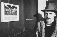 Image of sheet 19820390 photo 23: Christian Egger (Koch und Beitzer ehemalig: Café Boy und Restazrabt Tessinerkeller Räuberhöhle genannt, 2012 Grüntal) vor einem Bild aus der Zürcher Jugendbewegung im Monte Verità Museum. 1982 Ticino Tessin √ Schweiz Switzerland