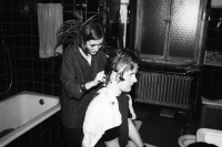 Image of sheet 19830000 photo 1: Komune Wohngemeinschaft Weinbergstrasse 84. Diane beim Haare schneiden. Christian Egger ehemals Wirt der Räuberhöhle, Tessinerkeller (abgebrochen 2011) und Café Boy.