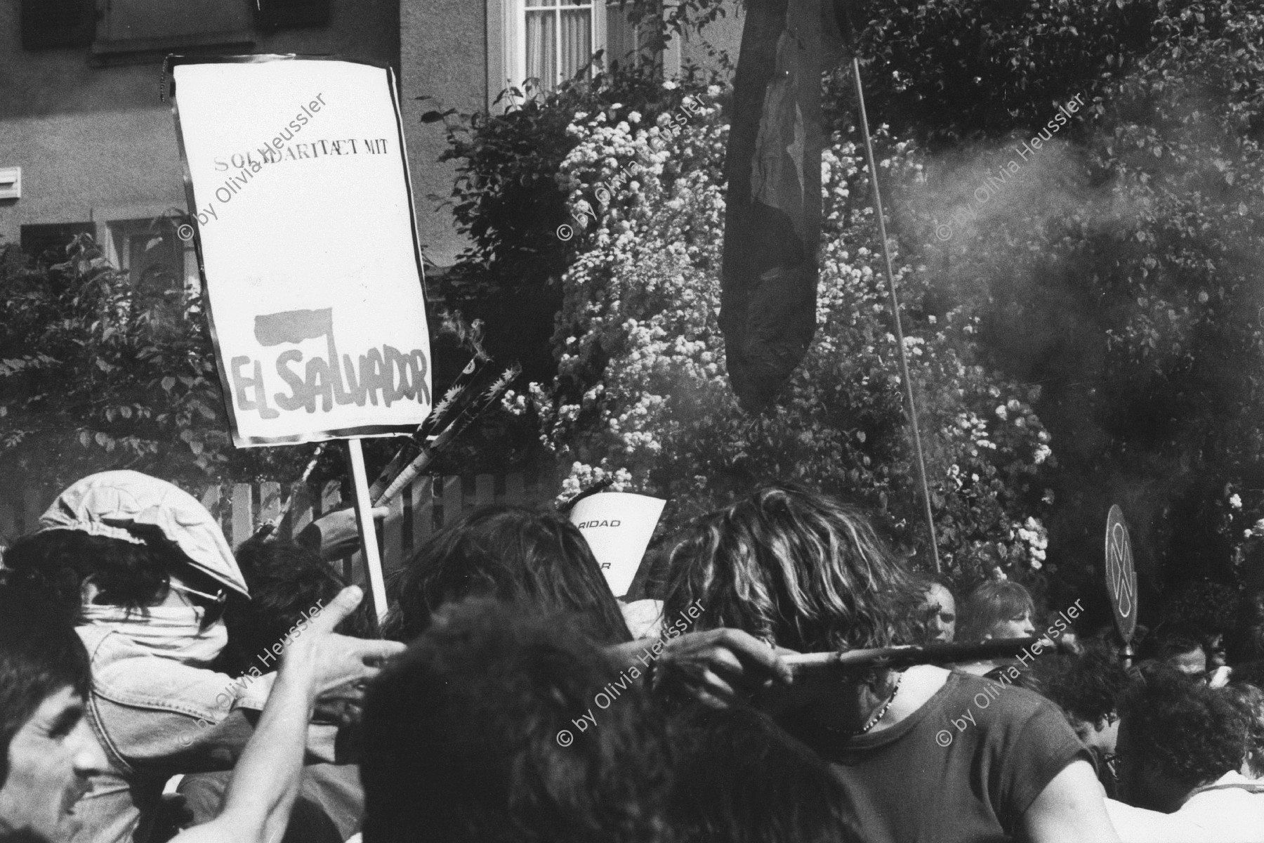 Image of sheet 19830141 photo 16: frtsg. 830140 Zentralamerika Demo in Bern. Vor US Botschaft. Solidarität mit El Salvador in der Solidarnosc Schrift auf Plakat. Hände mit Feuerwerken. Bern 1983 √