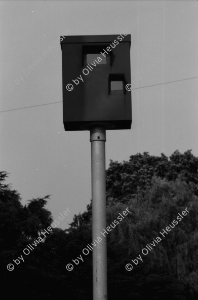 Image of sheet 19830150 photo 20: WOZ Schlieren und Kantonsschule Urdorf. Postgebäude Mülligen. Wagi Schlieren. Dorfplatz. Riegelhaus in Schlieren. Auto und Verkehr Strasse. Mann mit Gewehr und Hund vom Schweizer Künstler und Bildhauer Kurt Lorenz Metzler wirbt für die Waffenfabrik Fortschritt Zürich 1983  Autobahn in Bau an  Schulhaus vorbei. Lastkran Kran Kranen und Siedlungen.