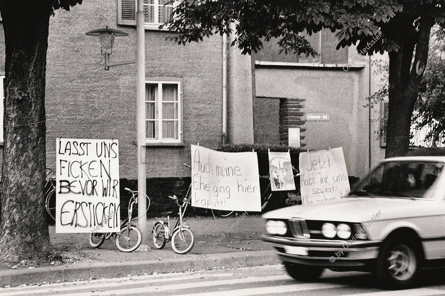 Image of sheet 19830250 photo 33: Protest gegen zunehmenden Verkehrs lärm an Stauffacherstrasse im Erismannhof. 'Lasst uns ficken bevor wir ersticken'. 
Wir sind ja so wach dank Pressluftkrach
Mein Mann flüstert mir immer zärtliche Wörter ins Ohr, aber ich verstehe einfach nichts.
Bürger Innen Aktion. Kreis 4 vier Aussersihl Zürich 1983 √ housing protest traffic noise city banner Zurich Schweiz Europe Switzerland