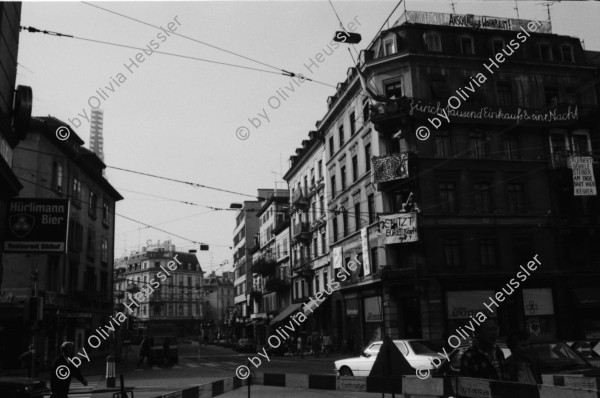 Image of sheet 19830250 photo 9: UBS Bank Hochhaus heute Steueramt Gebäude Werd Doppelbelichtung mit Tor zum Stauffacher. Besetzt. Bilder ab Monitor. Diabolik. Flugkörper. Protest gegen
 Verkehrslärm am Stauffacherstrasse im Erismannhof. Lasst uns ficken bevor wir ersticken. Bürger Innen Aktion. Zürich Kreis vier 4 Aussersihl 1983
© 1982, by Olivia Heussler www.oliviaheussler.com