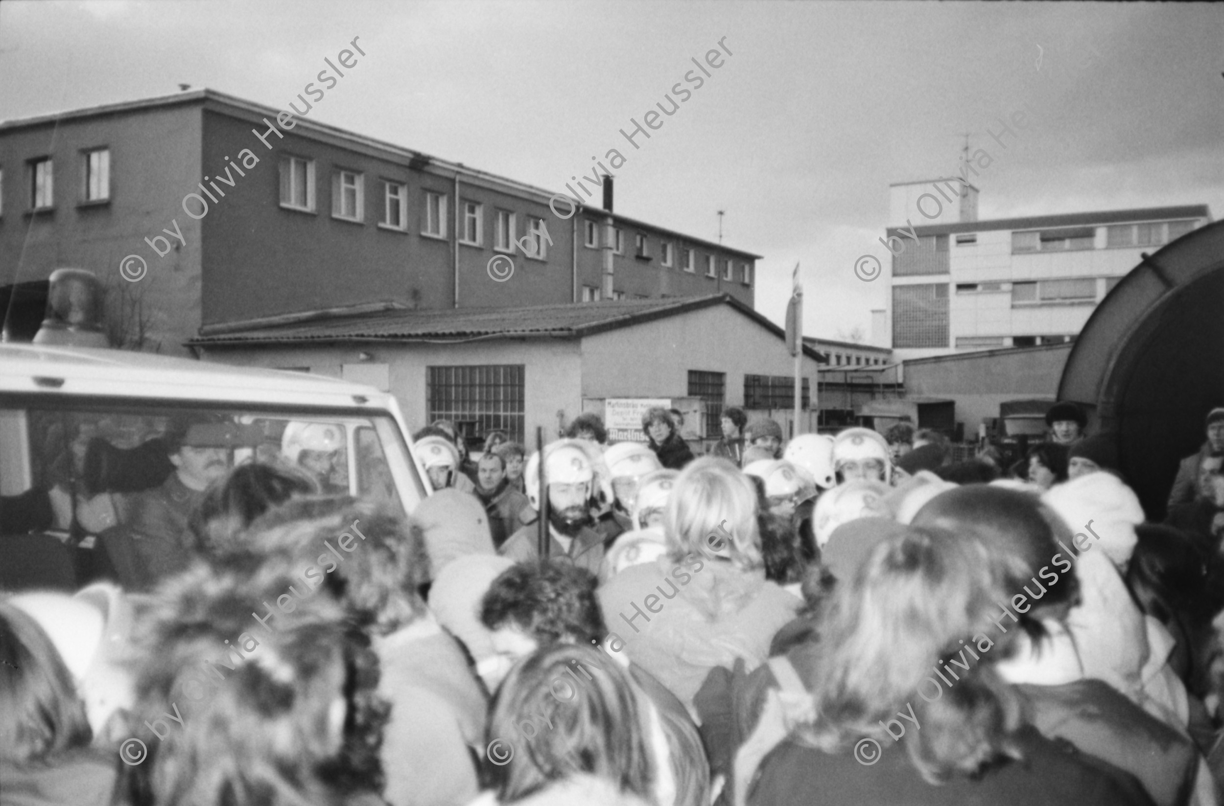 Image of sheet 19830300 photo 10: In Frankfurt Hausen ist eine Blockade gegen die Mittelstreckenraketen Depot im Gang. Die Polizei greift ein. Nachts werden die von der US- Armee bewachten Raketen in Containern weggefahren. Im Convoi fährt ein Rolls Royce 
Käthe Kollwitz Haus Strassentafel Frankfurt a. Main. Germany Deutschland 1983