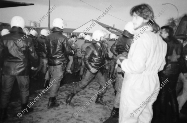 Image of sheet 19830300 photo 13: In Frankfurt Hausen ist eine Blockade gegen die Mittelstreckenraketen Depot im Gang. Die Polizei greift ein. Nachts werden die von der US- Armee bewachten Raketen in Containern weggefahren. Im Convoi fährt ein Rolls Royce 
Käthe Kollwitz Haus Strassentafel Frankfurt a. Main. Germany Deutschland 1983