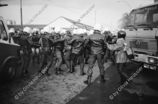 Image of sheet 19830300 photo 16: In Frankfurt Hausen ist eine Blockade gegen die Mittelstreckenraketen Depot im Gang. Die Polizei greift ein. Nachts werden die von der US- Armee bewachten Raketen in Containern weggefahren. Im Convoi fährt ein Rolls Royce 
Käthe Kollwitz Haus Strassentafel Frankfurt a. Main. Germany Deutschland 1983