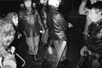 Image of sheet 19830300 photo 27: In Frankfurt Hausen ist eine Blockade gegen die Mittelstreckenraketen Depot im Gang. Die Polizei greift ein. Nachts werden die von der US- Armee bewachten Raketen in Containern weggefahren. Im Convoi fährt ein Rolls Royce 
Käthe Kollwitz Haus Strassentafel Frankfurt a. Main. Germany Deutschland 1983