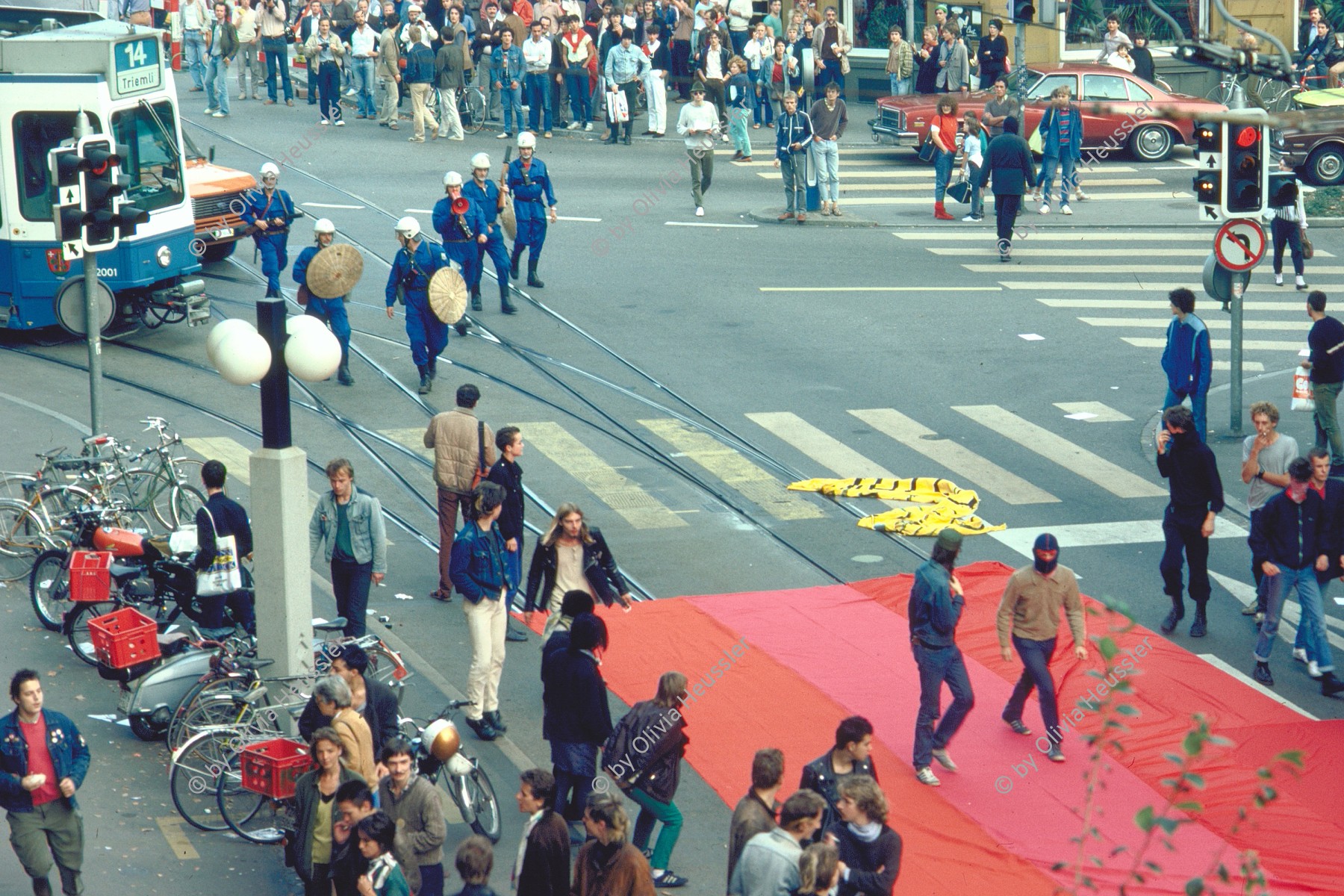 Image of sheet 19833000 photo 3: Am Tor zu Aussersihl
Am Stauffacherplatz Badenerstrasse wird das Eckhaus besetzt. Ein rotes Tuch wird auf den Platz über die Tramschienen der VBZ gelegt. Polizeibeamte nehmen das Tuch auf und die Leute reissen es ihnen aus den Händen. So geht es weiter durch die Stadt. Housing, Besetzung Wohnen, Wohnungsnot, Wohnungsmangel, protest action, art, installation,
Zürich Schweiz Switzerland
19833000_03
© 1983, by OLIVIA HEUSSLER / www.clic.li