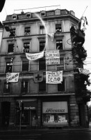 Image of sheet 19840010 photo 37: frtsg. Bar Helvti Hand Glas Bar. Stauffacher Besetzung Transparente 'No Pasaran' Polizei Demonstration 'Herr Bührle ein Lächeln wird sie besiegen' ZM Gebäude Zürich Wohnungsnot Wohnen Häuserkampf Hausbesetzung Zürich Badenerstrasse 1984 
Housing