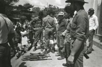 Image of sheet 19840100 photo 20: Nach einem Ueberfall, werden vom sandinistischen Militär, (re) gefangene Contrarebellen und ihre Waffen, der Bevölkerung vorgeführt. San Miguelito Rio San Juan, fsln sandinist war Contra  man young people population Central america Solidarity weapons rifle army military soldier