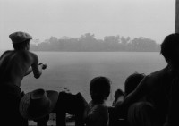 Image of sheet 19840110 photo 10: Schweizer Solidaritäts Brigade in Solentiname. Isla Zapotillo. Boot im See. Wäschebank im See. Vater mit Radio und Knabe. Brigadisten Innen fängt Regen mit Hand auf. Junge besprayt Pferd. Campesino auf Pony mit Rinder. Assentamiento Siedlung. In the house of a settlement for war refugees.
Baseballspieler Baseball Asentamiento Strohhütte Kinder stehen vor Palmwedeln Palmen in Siedlung. Laurel y Galan. (Lorbeer) Machetenschleifen. Adobe haus Hacienda. Einfacher Hausbau in Matagalpa. Nicaragua 1984

Aus: Der Traum von Solentiname/The dream of Solentiname/El sueño de Solentiname
