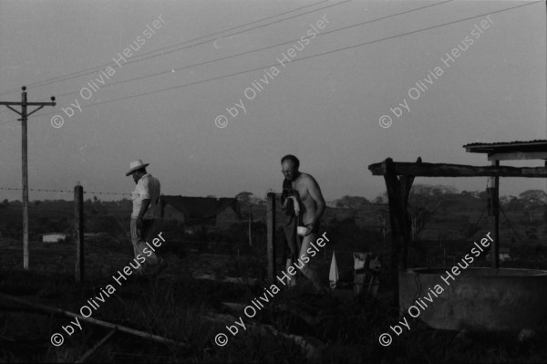 Image of sheet 19840110 photo 12: Schweizer Solidaritäts Brigade in Solentiname. Isla Zapotillo. Boot im See. Wäschebank im See. Vater mit Radio und Knabe. Brigadisten Innen fängt Regen mit Hand auf. Junge besprayt Pferd. Campesino auf Pony mit Rinder. Assentamiento Siedlung. In the house of a settlement for war refugees.
Baseballspieler Baseball Asentamiento Strohhütte Kinder stehen vor Palmwedeln Palmen in Siedlung. Laurel y Galan. (Lorbeer) Machetenschleifen. Adobe haus Hacienda. Einfacher Hausbau in Matagalpa. Nicaragua 1984

Aus: Der Traum von Solentiname/The dream of Solentiname/El sueño de Solentiname