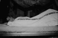 Image of sheet 19840140 photo 1: Sandinist mit unter Leintuch des Ejercito Popular Sandinista. Transparent Schweizer Brigaden. Arbeitsbrigade Brigadisten Brigadistinnen Brigada Suiza. Latrinenbau. Wolfgang Vogel Winterthur Ceibo. Isla de Zapotillo Willy aus Aarau mit Leguane Iguanas. Nicas und Schweizer. Fischerboote. Rudern Insel im Nicaragua see. Solentiname Archipelago de Solentiname. Abendstimmung. Nicaraguaner lernt englisch. Rio San Juan San Carlos Nicaragua 1984