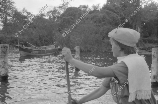 Image of sheet 19840140 photo 21: Sandinist mit unter Leintuch des Ejercito Popular Sandinista. Transparent Schweizer Brigaden. Arbeitsbrigade Brigadisten Brigadistinnen Brigada Suiza. Latrinenbau. Wolfgang Vogel Winterthur Ceibo. Isla de Zapotillo Willy aus Aarau mit Leguane Iguanas. Nicas und Schweizer. Fischerboote. Rudern Insel im Nicaragua see. Solentiname Archipelago de Solentiname. Abendstimmung. Nicaraguaner lernt englisch. Rio San Juan San Carlos Nicaragua 1984