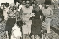 Image of sheet 19840160 photo 29: Ehefrau. Beerdigung eines sandinistischen Soldaten. Mädchen tragen Blumen. Familie am Grab und Sarg. Tochter, Mutter und Grossmutter trauern. San Juan del Sur Begräbnis von Joé Herrera. Nicaragua 1984 √