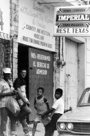 Image of sheet 19840180 photo 23: US-Army Soldaten in Zivil vor Bar. Honduranische Junge und Soldaten. Honduras Mittelamerika Centralamerica 1984 √ military armee USA contra war against sandinist nicaragua boys children Bar Country and Western music Houston dining room in back. Restaurant Texas Imperial beer tipo pilsener street 
© 1984, OLIVIA HEUSSLER / www.clic.li