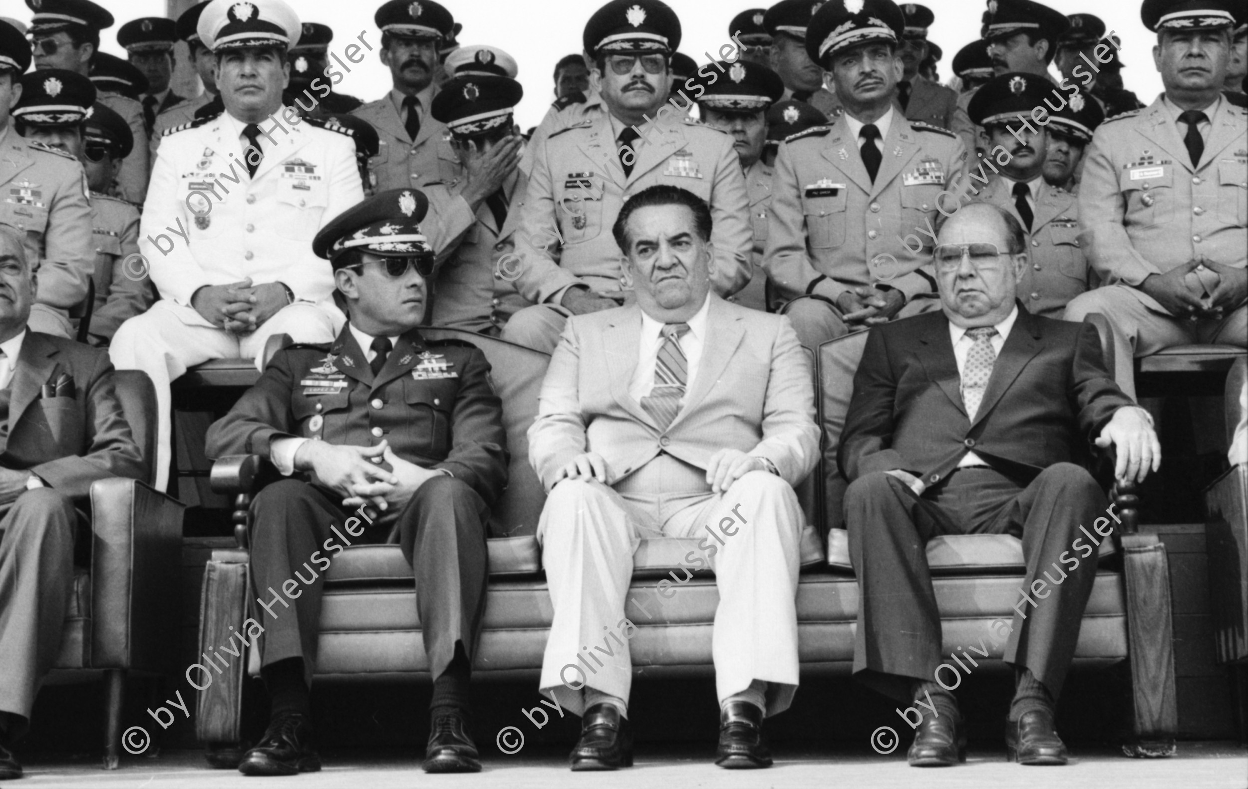 Image of sheet 19840190 photo 29: At the military parade in honor of the new Honduran commander-in-chief, General Walter López Reyes (l.) with President Suazo Córdoba (center), and Chief Justice Efraín Bu Girón (r.).
Las Tapias, Tegucigalpa, Honduras, April 1984.
Militärparade anlässlich der Befehlsübergabe an den neuen honduranischen Armeechef,
General Walter López Reyes (l.) mit Staatspräsident Suazo Córdoba (Mitte)
und Staatsanwalt Efrain Bu Girón (r.). Las Tapias, Tegucigalpa, Honduras, April 1984
Aus: «Der Traum von Solentiname» EPF, Zürich 
«El Sueño de Solentiname» IHNCA Managua p.44