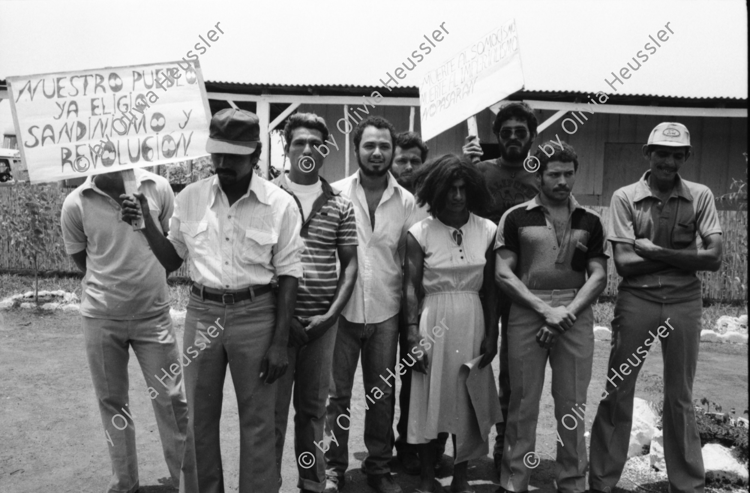 Image of sheet 19840230 photo 32: In der offenen Strafanstalt Gefängniss 'La Granja'. Die Insassen spielen den Besucher Innen ein antiimperialisctisches Polit theaterstück vor. «Fuera Yankees. Fuera Traidores» Raus Amerikaner. Raus Verräter. «Basta de minar los Puertos» Aufhören mit der Verminung unserer Häfen. Zwei männliche Gefangene als Frauen verkleidet. Nahe Managua Nicaragua Carretera Norte 1984