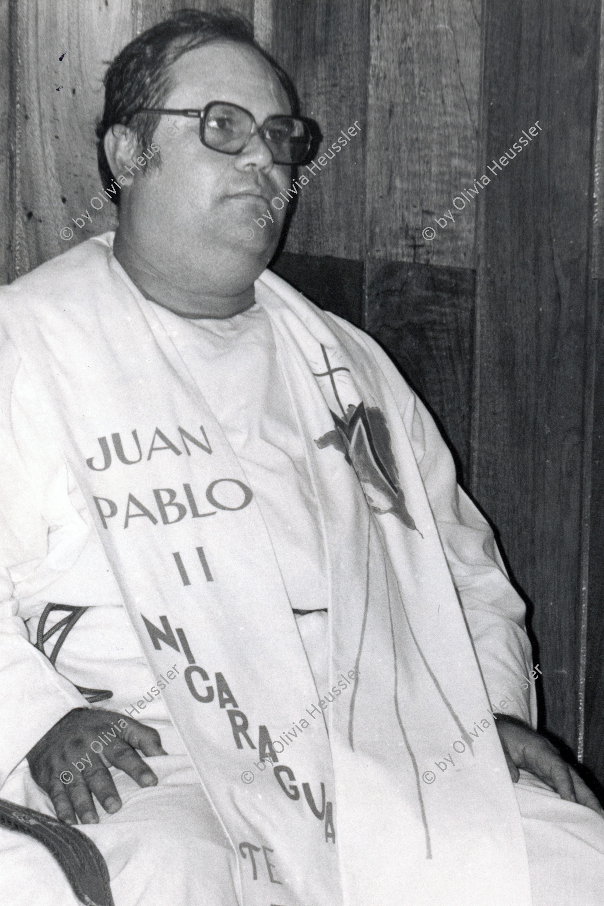 Image of sheet 19840250 photo 21: In der Kirche Don Bosco wird zum 1. Mai eine antisandinistische Rede gehalten. Pablo Antonio Vega hält die Rede. Amado Peña, heute Capellán del Sistema Penitenciario wird später von den Sandinisten wegen Handel mit Waffen verhaftet. Er trägt eine Shärpe Schal wo drauf steht: Juan Pablo II Nicaragua ist dir treu. Nicaragua 1984 √