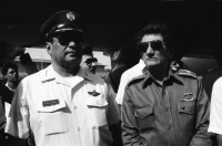 Image of sheet 19840280 photo 10: Sandinistische Komandanten im CAS. Ortega (Humberto und Daniel). Tomas Borge, Jaime Wheelock etc. Tote honduranische Soldaten im Flughafen in Särgen werden von ihren Staatsvertreter abgholt Sie starben nach einem Helikopterabschuss durch sandinistische Truppen. Ein Journalist hält das Mikrofon an den Sarg. Nicaragua Managua 8. Mai 1984