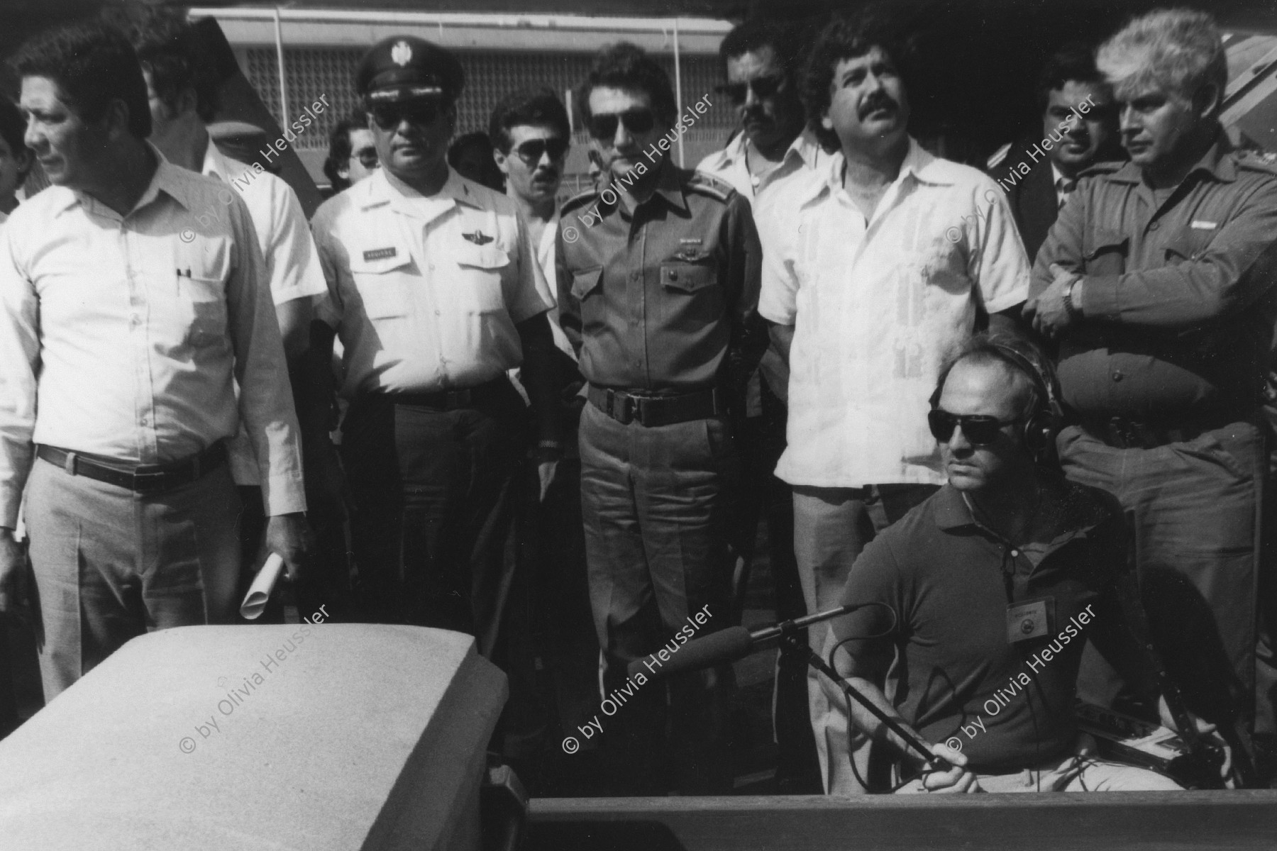 Image of sheet 19840280 photo 12: Tote honduranische Soldaten im Flughafen in Särgen werden von ihren Staatsvertreter abgholt Sie starben nach einem Helikopterabschuss durch sandinistische Truppen. Ein Journalist hält das Mikrofon an den Sarg. Nicaragua Managua 8. Mai 1984 √