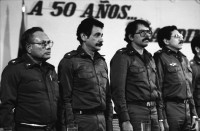 Image of sheet 19840280 photo 21: Sandinistische Komandanten im CAS. Ortega (Humberto und Daniel). Tomas Borge, Jaime Wheelock etc. Tote honduranische Soldaten im Flughafen in Särgen werden von ihren Staatsvertreter abgholt Sie starben nach einem Helikopterabschuss durch sandinistische Truppen. Ein Journalist hält das Mikrofon an den Sarg. Nicaragua Managua 8. Mai 1984
