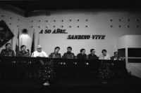 Image of sheet 19840280 photo 23: Sandinistische Komandanten im CAS. Ortega (Humberto und Daniel). Tomas Borge, Jaime Wheelock etc. Tote honduranische Soldaten im Flughafen in Särgen werden von ihren Staatsvertreter abgholt Sie starben nach einem Helikopterabschuss durch sandinistische Truppen. Ein Journalist hält das Mikrofon an den Sarg. Nicaragua Managua 8. Mai 1984