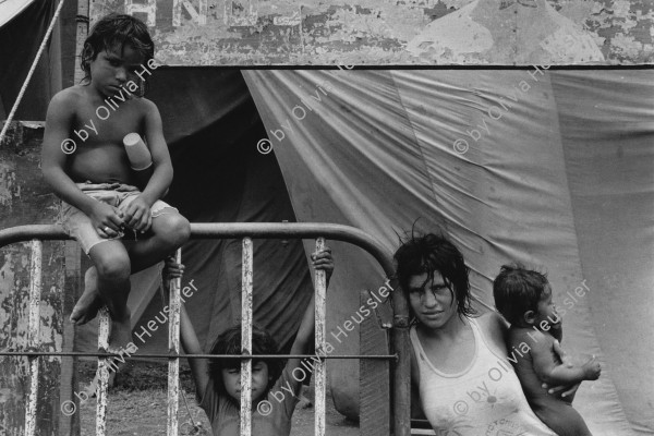 Image of sheet 19840320 photo 17: Eine junge Mutter mit ihren Kindern arbeitet im Zirkus Margot. San Juan del Sur, Nicaragua 04.06.84 1984 
Young mother with kids in front of Circus Margot. circo