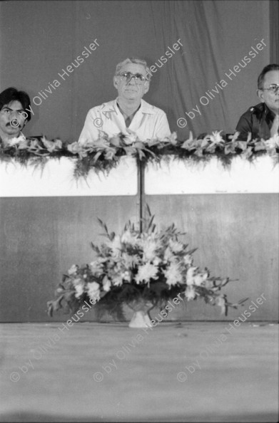 Image of sheet 19840330 photo 2: Luis Enrique Mejia Godoy  in Managua. Kommandant Comandante Tomas Borge unter dem Abbild von Carlos Fonseca. Soldaten Bill Gentil fotografiert leere Stühle und Soldaten. alter Soldat und Sandinist. Junge Sandinistinnen und Mütter gefallener Soldaten protestieren Protest Amerikanische Journalistin Cookie Hood und Soldaten.
1984 Nicaragua