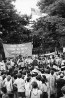 Image of sheet 19840410 photo 25: Viele Nordamerikaner Innen demonstrieren vor ihrer Botschaft. Protest US Amerikaner innen. U.S.A. Portrai Frau mit hut. Die Fahne weht auch stolz über ihr. Peace means stoping US backed Invasion of Nicaragua. Marsch am 19.Juli auf der Carretera Norte, vorbei an den Texnicsa. Wandbild mit Sandino.