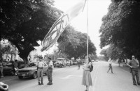 Image of sheet 19840410 photo 27: Viele Nordamerikaner Innen demonstrieren vor ihrer Botschaft. Protest US Amerikaner innen. U.S.A. Portrai Frau mit hut. Die Fahne weht auch stolz über ihr. Peace means stoping US backed Invasion of Nicaragua. Marsch am 19.Juli auf der Carretera Norte, vorbei an den Texnicsa. Wandbild mit Sandino.