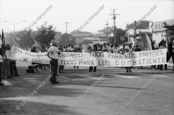 Image of sheet 19840410 photo 41: Viele Nordamerikaner Innen demonstrieren vor ihrer Botschaft. Protest US Amerikaner innen. U.S.A. Portrai Frau mit hut. Die Fahne weht auch stolz über ihr. Peace means stoping US backed Invasion of Nicaragua. Marsch am 19.Juli auf der Carretera Norte, vorbei an den Texnicsa. Wandbild mit Sandino.