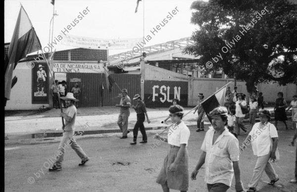 Image of sheet 19840410 photo 47: Viele Nordamerikaner Innen demonstrieren vor ihrer Botschaft. Protest US Amerikaner innen. U.S.A. Portrai Frau mit hut. Die Fahne weht auch stolz über ihr. Peace means stoping US backed Invasion of Nicaragua. Marsch am 19.Juli auf der Carretera Norte, vorbei an den Texnicsa. Wandbild mit Sandino.