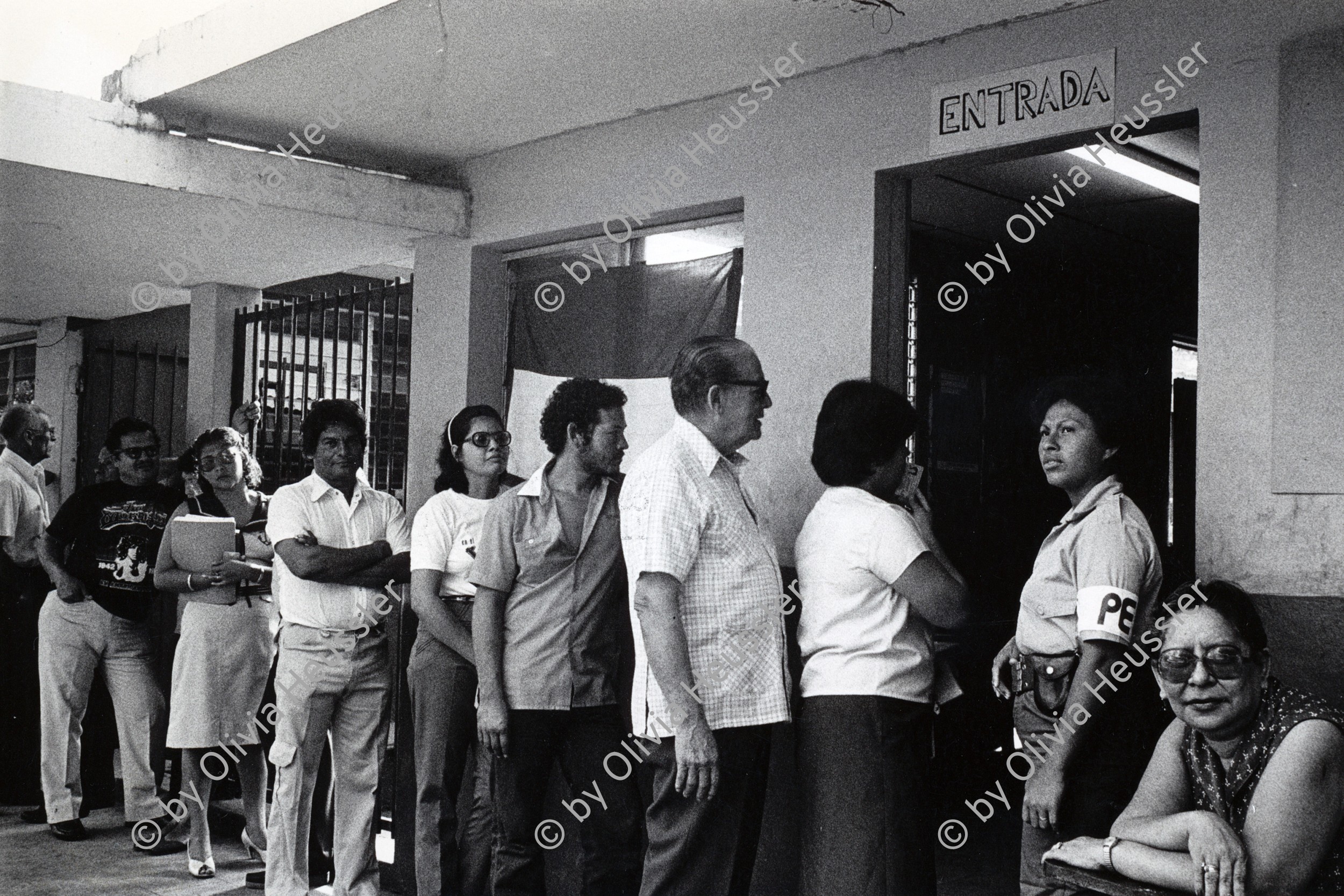 Image of sheet 19840460 photo 32: Wahllokal Schlange stehende Menschen vor Büro zur Einschreibung für die Wahlen vom November. Managua Nicaragua 1984 √ first democratical election local men and women democrats FSLN central america

People standing in queue in front of a polling station office for enrollment for the November elections.