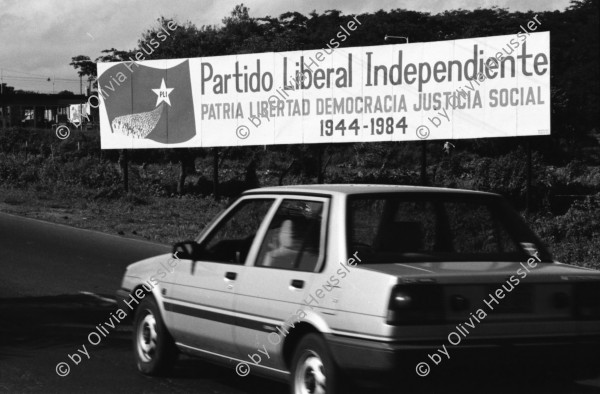 Image of sheet 19840500 photo 25: Majorettes treten für Daniel Ortega auf. Kindergruppe. Kirche von Bluefields. Esso Tankstelle. kleine Fischerboote im Hafen von B-. Palmen. Kinder vor Wandmalerei. Mascotta. kleines Mädchen als Kindersoldat verkleidet. S.M.P. Servicio Militar Patriotico. Tafel des P.L.I. in Managua. Partido Liberal Independiente. Atlantikküste RAAS 1984