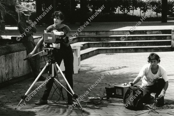 Image of sheet 19840510 photo 40: Sandinist Kommandant Cmdte. Daniel Ortega lässt sich für den Film von Hans Langenberg, (NL) interviewen. Gabriela Baur mit Camera filmt und Olivia Heussler als Tonfrau Technikerin Ton. Portrait. Nicaragua 1984 √