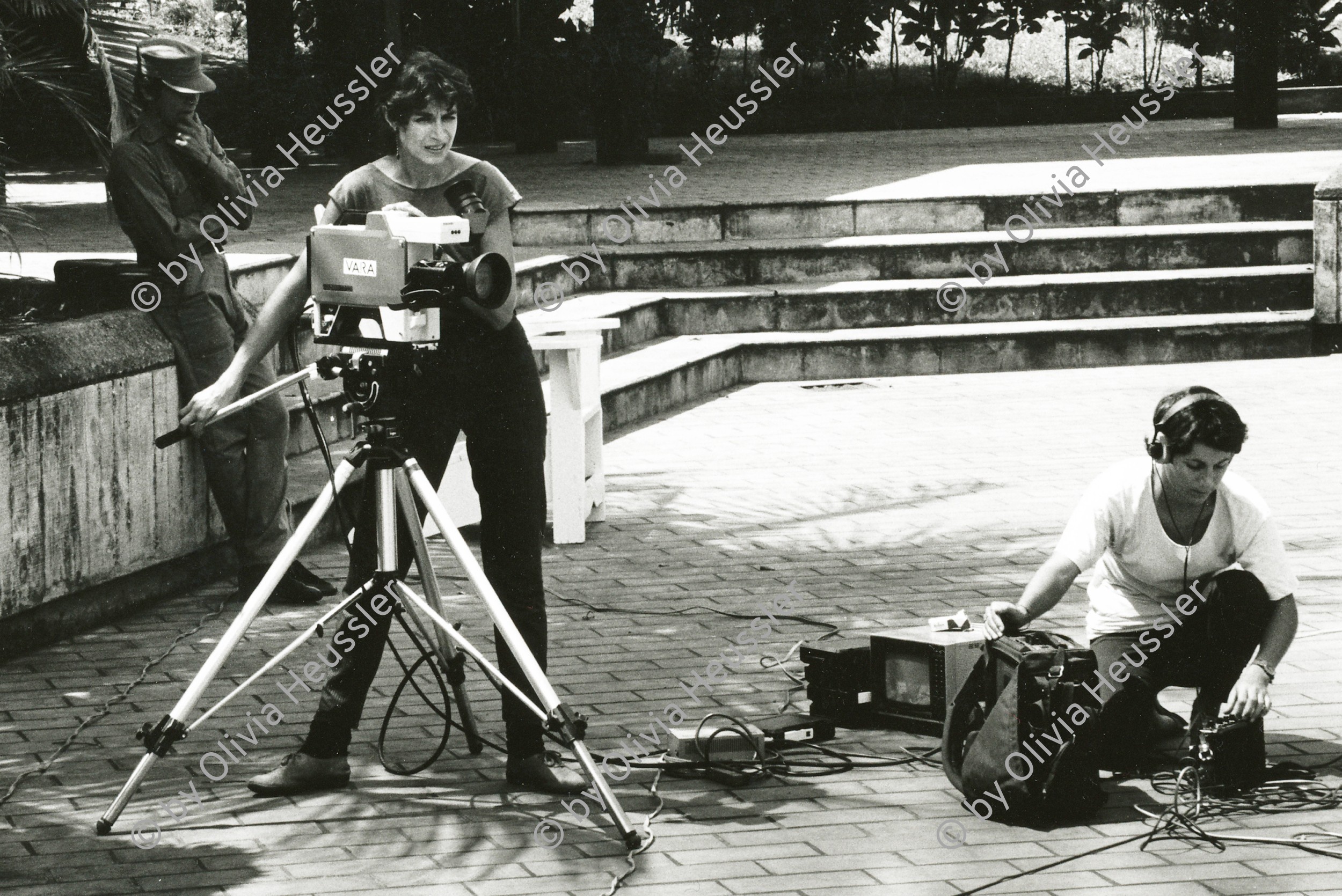 Image of sheet 19840510 photo 41: Sandinist Kommandant Cmdte. Daniel Ortega lässt sich für den Film von Hans Langenberg, (NL) interviewen. Gabriela Baur mit Camera filmt und Olivia Heussler als Tonfrau Technikerin Ton. Portrait. Nicaragua 1984 √ Journalismus Reportage