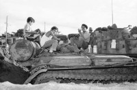 Image of sheet 19840660 photo 23: russische sovietische Tanks Panzer EPS stehen um Managua herum. Invasionsangst Kind mit Taube steht vor Panzer. Gewehre gegen den Himmel gerichtet. Panzer ist mit Pflanzen getarnt. Mann fotografiert sein Kollege auf Panzer stehend. Mann fotografiert. Managua Nicaragua 1984