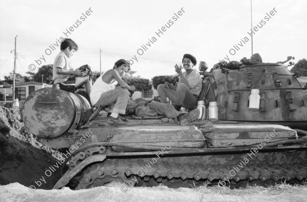 Image of sheet 19840660 photo 23: russische sovietische Tanks Panzer EPS stehen um Managua herum. Invasionsangst Kind mit Taube steht vor Panzer. Gewehre gegen den Himmel gerichtet. Panzer ist mit Pflanzen getarnt. Mann fotografiert sein Kollege auf Panzer stehend. Mann fotografiert. Managua Nicaragua 1984