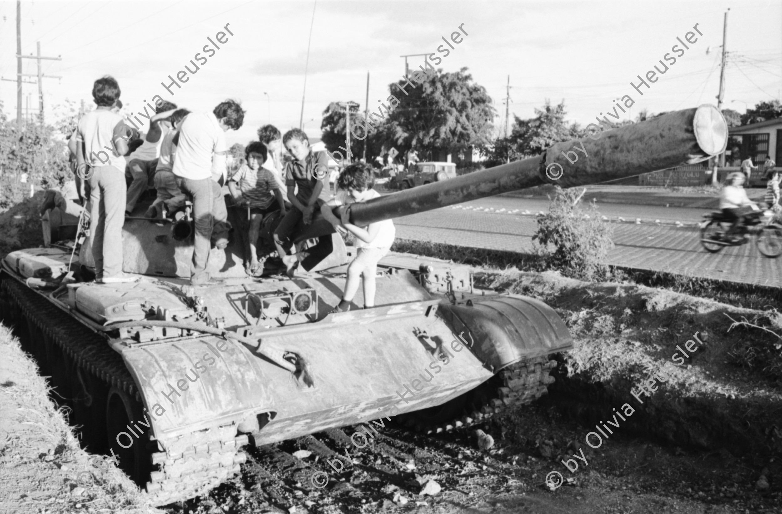Image of sheet 19840660 photo 25: russische sovietische Tanks Panzer EPS stehen um Managua herum. Invasionsangst Kind mit Taube steht vor Panzer. Gewehre gegen den Himmel gerichtet. Panzer ist mit Pflanzen getarnt. Mann fotografiert sein Kollege auf Panzer stehend. Mann fotografiert. Managua Nicaragua 1984