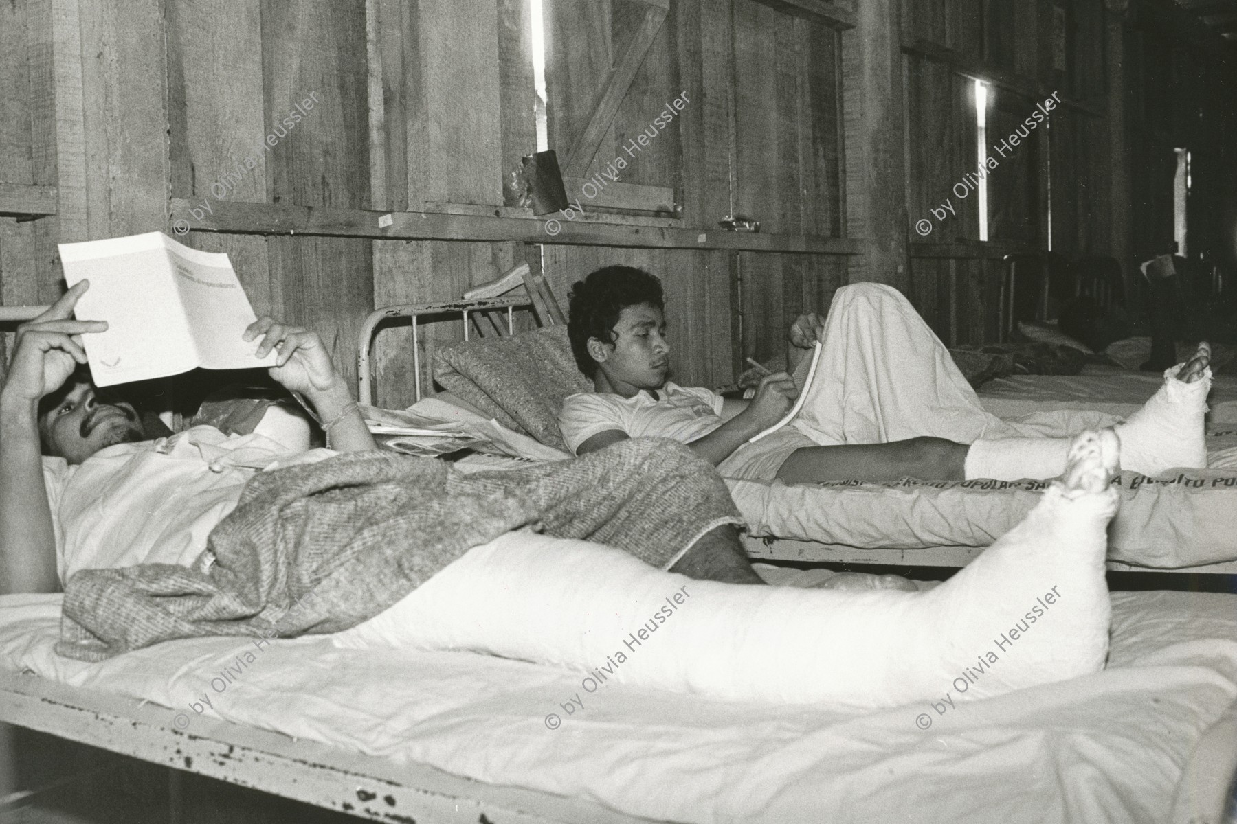 Image of sheet 19840690 photo 11: Verwundete Soldaten des Ejercito Popular Sandinista EPS nach einem Angriff der Contrarebellen der FDN, lesen im Bett. 

Wounded soldiers of the Ejercito Popular Sandinista EPS after an attack of the Contra rebels FDN reading in bed
Nicaragua Apanas Jinotega 1984 √ military health clinic Hospital Spitalbett Spital 

The Sandinista Popular Army (or People's Army; Ejército Popular Sandinista, EPS) was the military established in 1979 by the new Sandinista government to replace the National Guard, following the overthow of Anastasio Somoza Debayle.