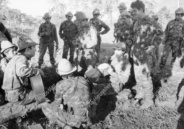 Image of sheet 19840690 photo 18: Flugaufnahme aus Helikopter. Soldatin kocht unter Zeltplane. Verwundete Soldaten des Ejercito Popular Sandinista EPS nach einem Angriff der Contrarebellen der FDN, spielen Schach. und lesen im Bett. Verwundeter wird aus Helikopter geladen. Es ist der Pilot des anderen Helis. Alouette, Die Aluette ist noch aus Beständen des Somoza-Clans. Die Sandinisten kannten dieses Fluggerät nicht und haben uns prompt auf dem Flug nach San José de Bocay beschossen.
Wir konnten aber ohne Probleme landen. Soldaten spielen Musik. Ausgediente Soldatenstiefel liegen am Boden auf einem Haufen. Ein junger Soldat isst seine Eierspeise elegant auf Tortilla und seinem Hut als Tisch. Die Tortilla dient als Teller. So verbrennt er seine Finger nicht. 
Nicaragua Apanas Jinotega 1984
Pop-Gruppe in Managua. Musikgruppe Igni Tawanka Olivia Portrait im TV-Monitor.