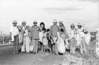 Image of sheet 19850040 photo 20: Frauen einer Kooperative ernten Baumwolle. Vulkan im Hintergrund. Sie gehen auf der Panamericana. Gruppenbild der Arbeiterinnen. Sie tragen Hüte die mit dem Namen Nicaragua bestickt sind. Eine Familie schleppt ein Wasser Wassertransport über die Landstrasse. Chinandega Nicaragua 1985