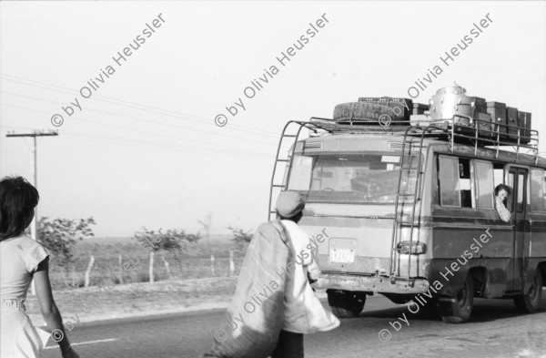 Image of sheet 19850040 photo 23: Frauen einer Kooperative ernten Baumwolle. Vulkan im Hintergrund. Sie gehen auf der Panamericana. Gruppenbild der Arbeiterinnen. Sie tragen Hüte die mit dem Namen Nicaragua bestickt sind. Eine Familie schleppt ein Wasser Wassertransport über die Landstrasse. Chinandega Nicaragua 1985