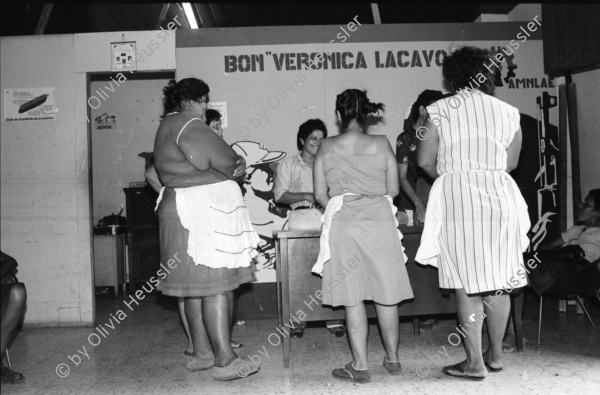 Image of sheet 19850050 photo 33: Bananenkooperative San Carlos. waschen und Einpacken der Bananen in Kartonschachteln. Die Frauen sammeln auf der Strasse für die Soldaten Geld. Vor dem AMNLAE Büro. Sandinistische Frauen Organisation. Der Tisch ist schon voller Spenden. Frauengruppe. Portrait. Gladys Baez vor Fotografien aller Komandanten. 
Nicaragua 1985