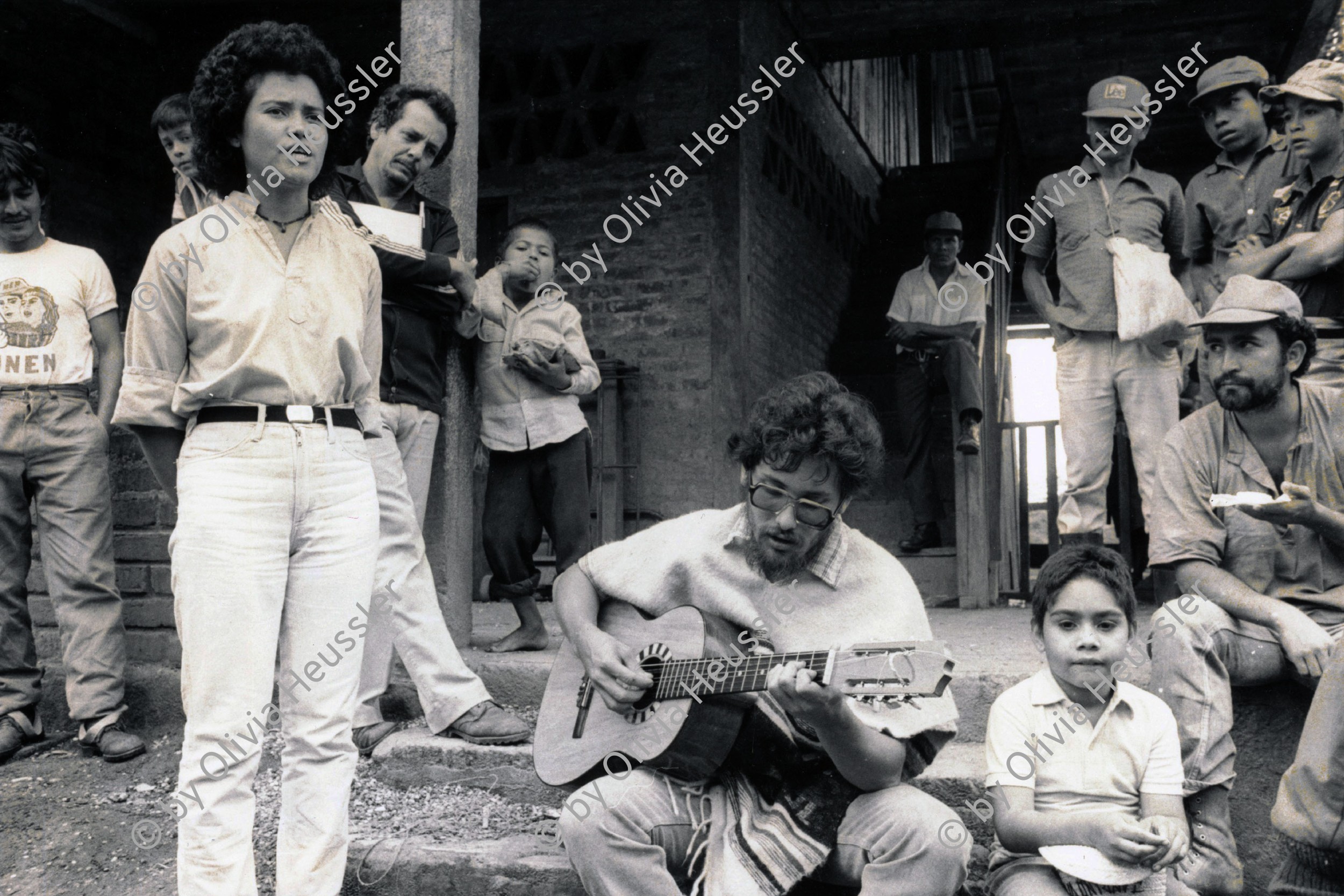 Image of sheet 19850060 photo 23: Kaffeeernte mit der Brigade von Inies und IRENA in der UPE empresas agropecuarias estatales, La Pintada. Lorenzo Cardenal (selig) spielt Gitarre.
 Musik Music Sandinista Sandinist Nicaragua 1985 √